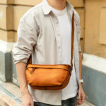 Young traveler using men genuine leather chest bag 9261 in airport scenario