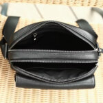 Close-up of top grain leather texture, zipper and inner compartments of men's shoulder bag.